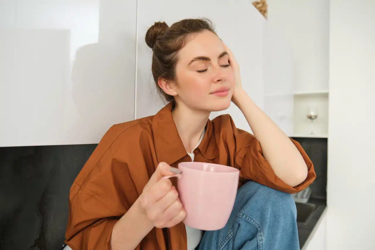 portrait-young-woman-with-cup-coffee-sits-kitchen-drinks-aromatic-drink-home-holds-1280×853.jpg