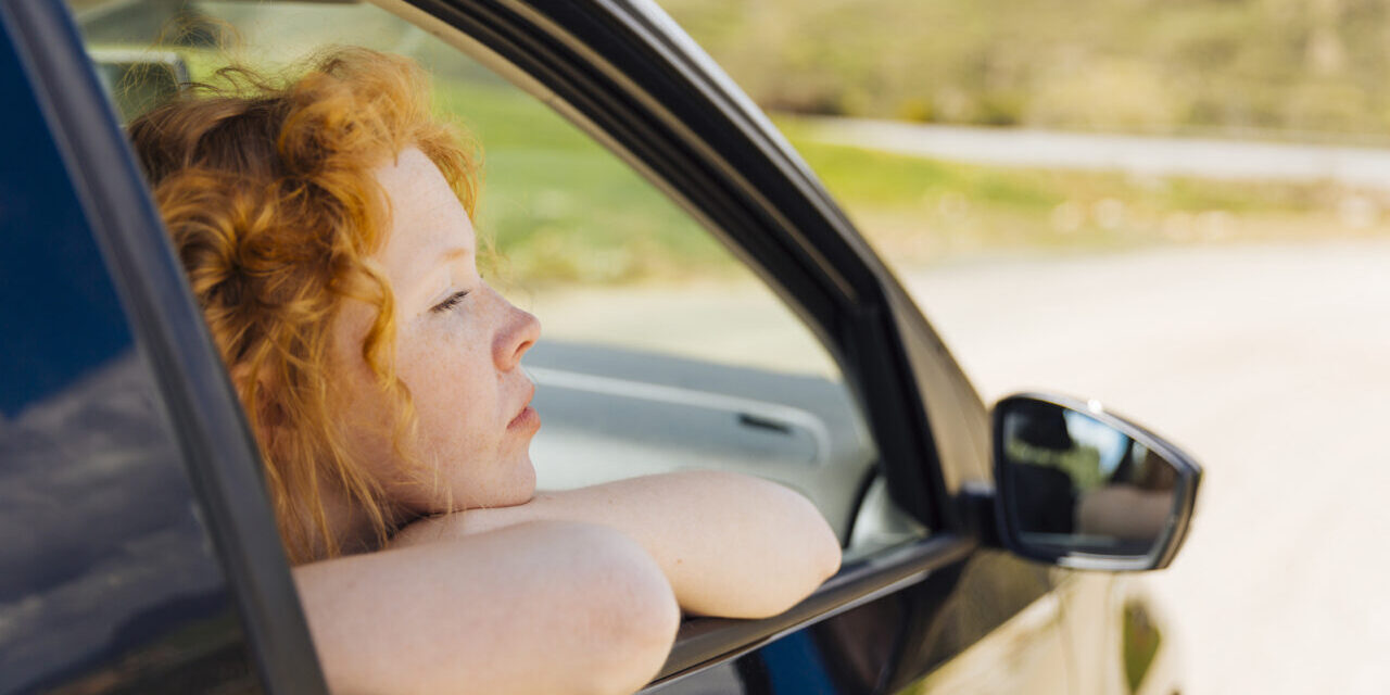 young-female-looking-out-car-window-1280×853