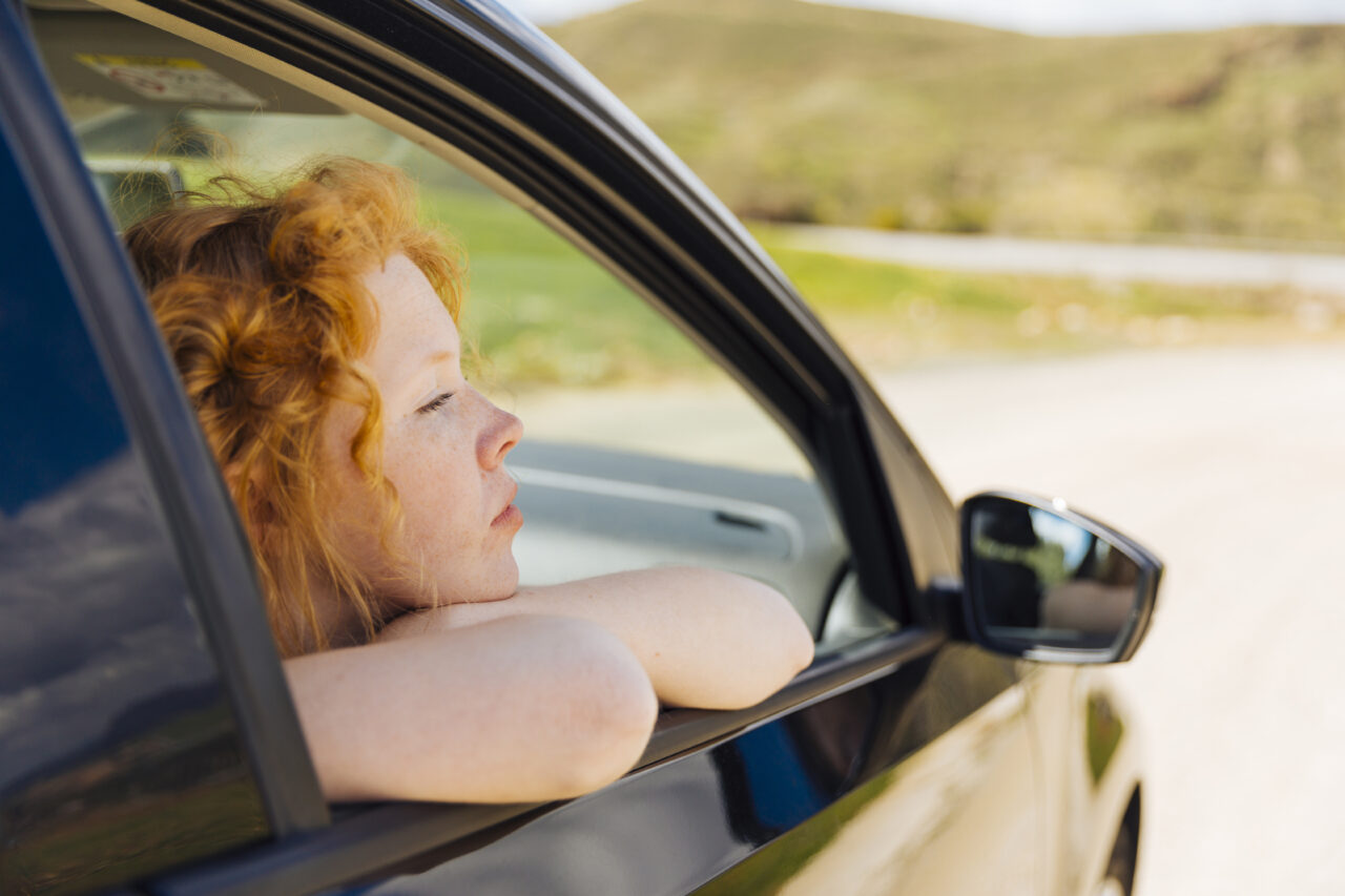 young-female-looking-out-car-window-1280×853